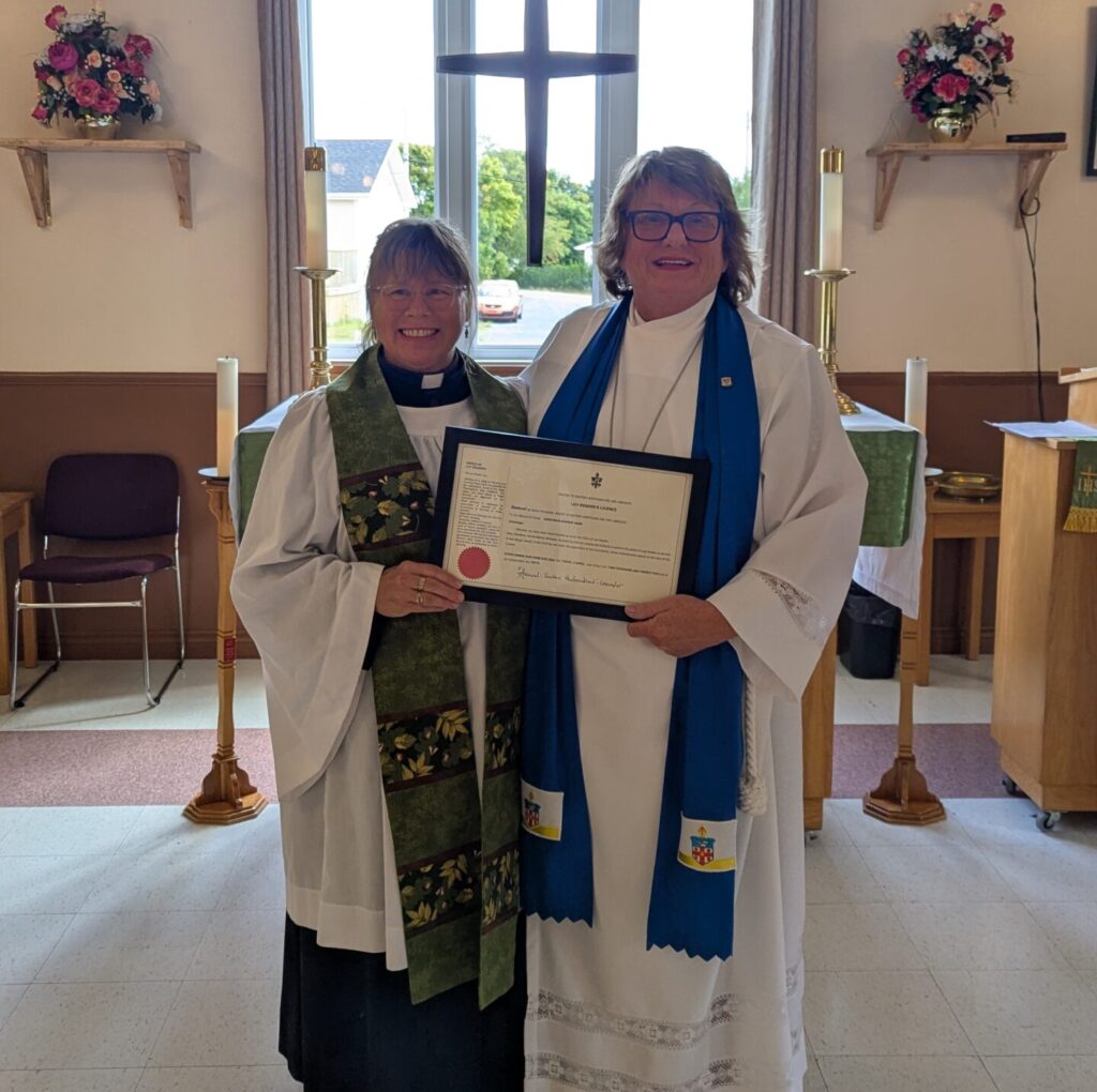 two women, one dressed as a priest and one as a lay reader, in front of an altar