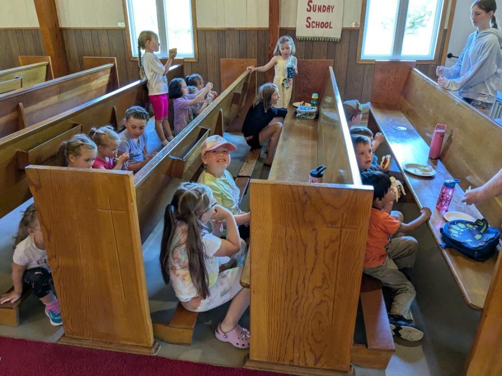 children eating a snack in a church pew