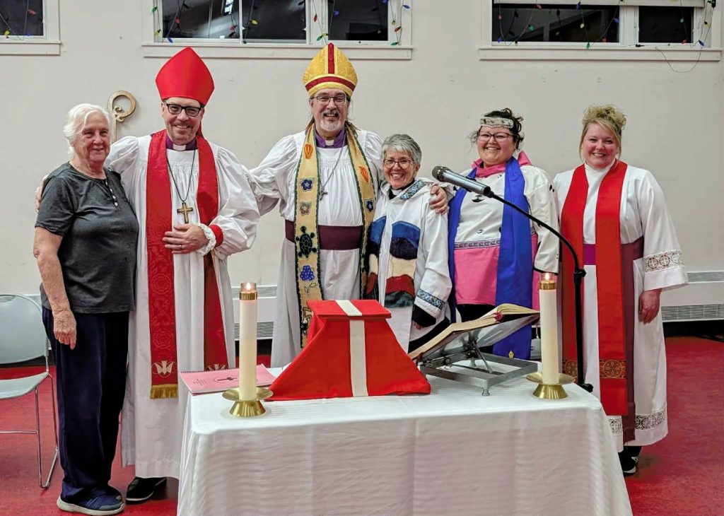 a group of people standing behind an altar all in various clerical clothing