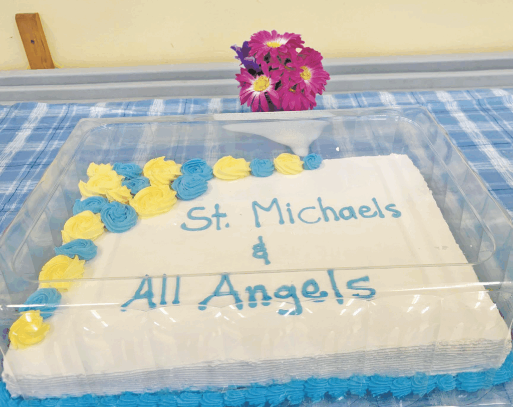 a cake decorated to say "St. Michaels & All Angels in blue icing