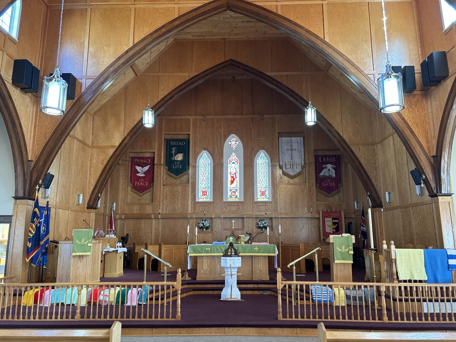 prayer shawl draped over the communion rail at the front of a wooden church