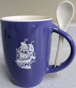 blue mug with a white image of a saling ship and a row boat