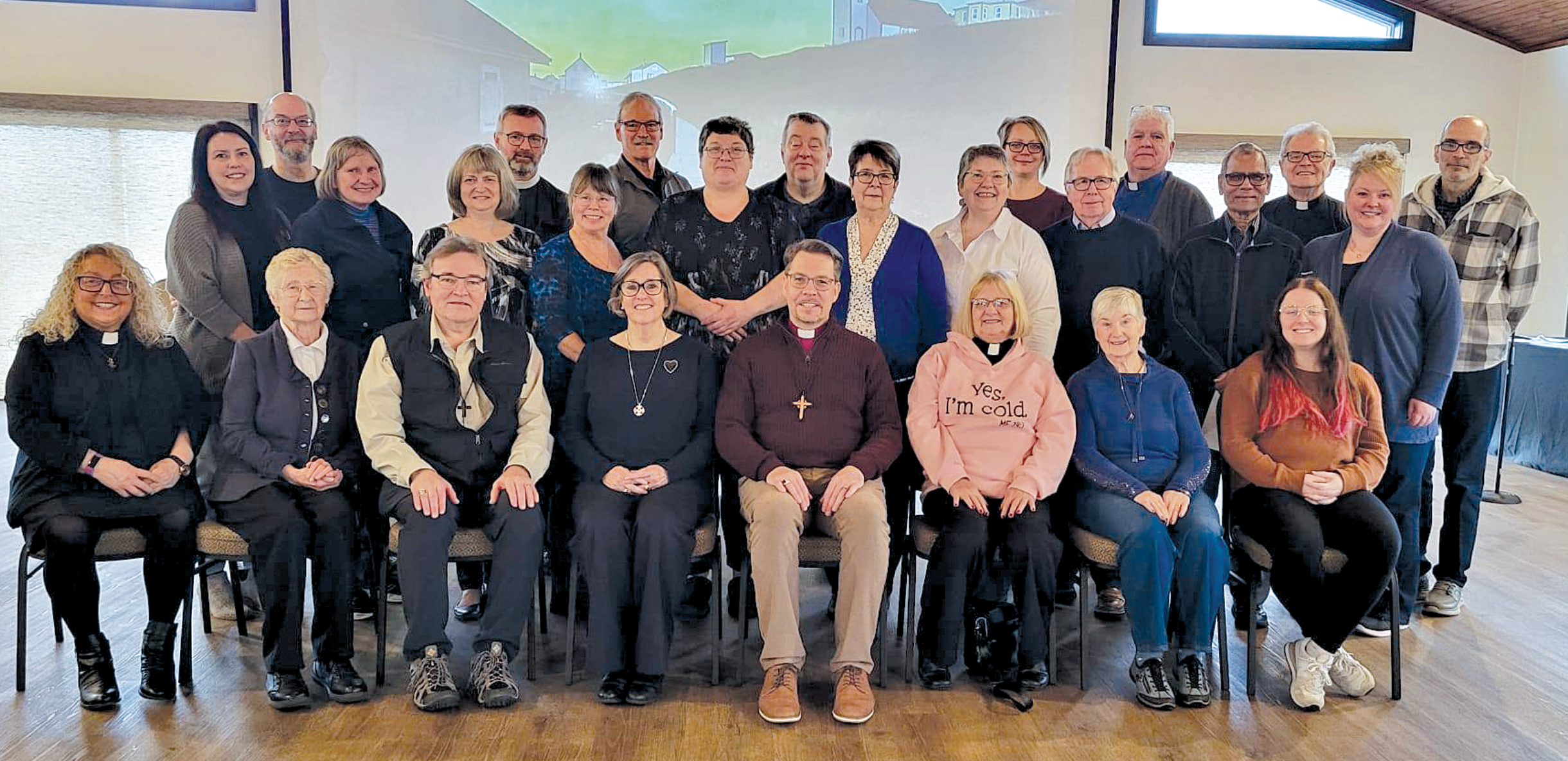 Group portrait of clergy and staff members indoors.