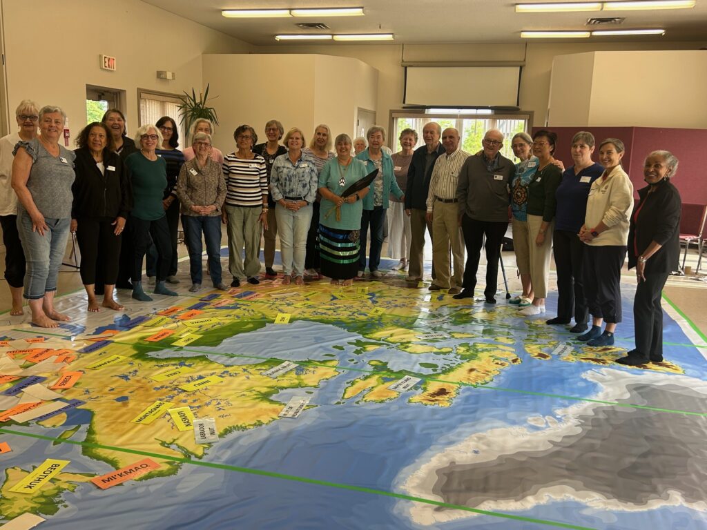 Group standing around large floor map.