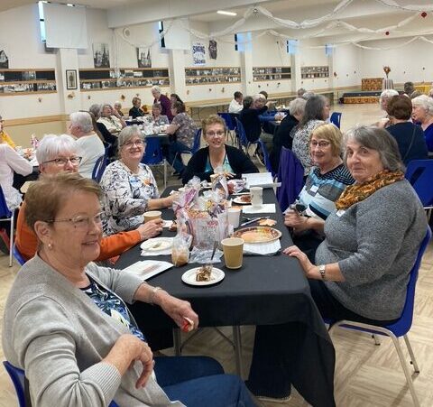 Group of women sitting at tables during an event.