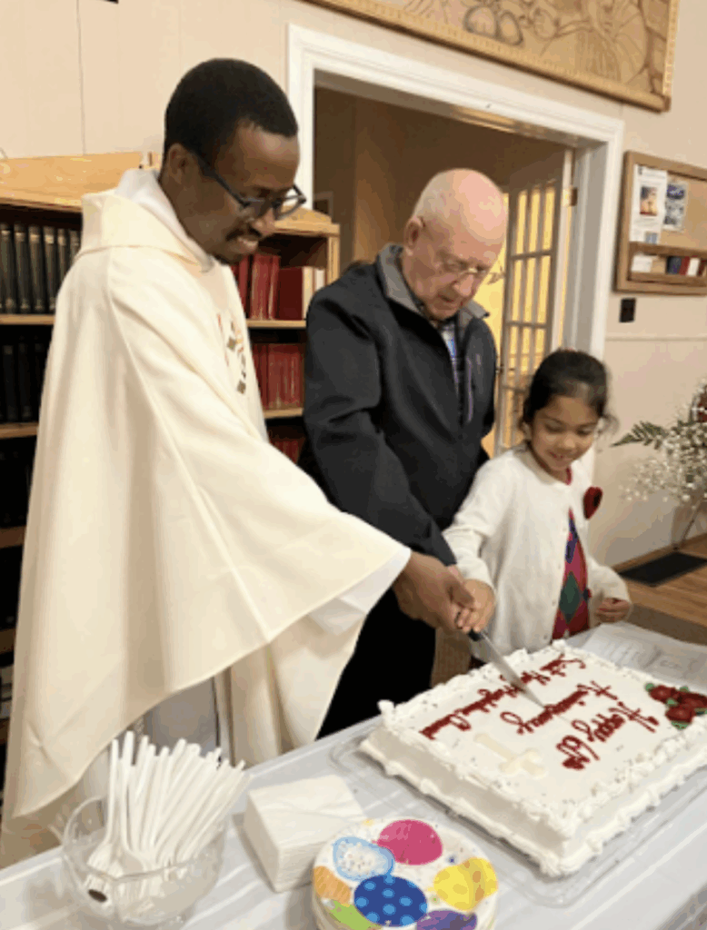 Three people smiling while cutting a celebratory sheet cake together.