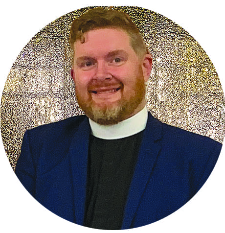 headshot of a young priest with red hair and beard