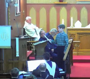 young person singing at a podium in a church