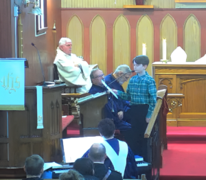young person singing at a podium in a church