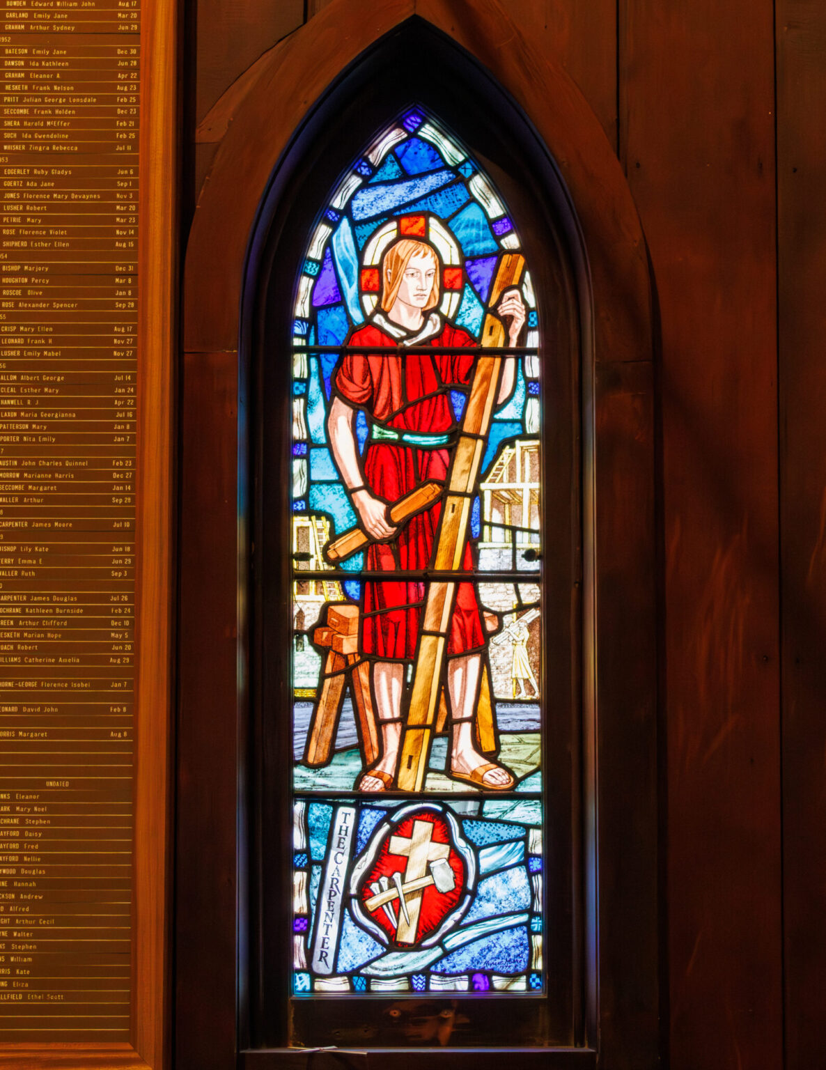 a stained glass window depicting Jesus as a carpenter