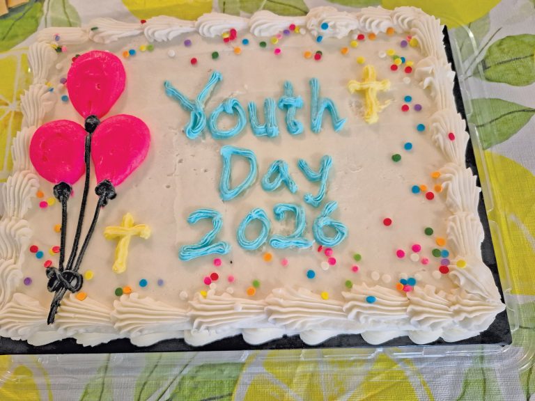 cake with frosting ballons and crosses that says "Youth Day 2026" on it