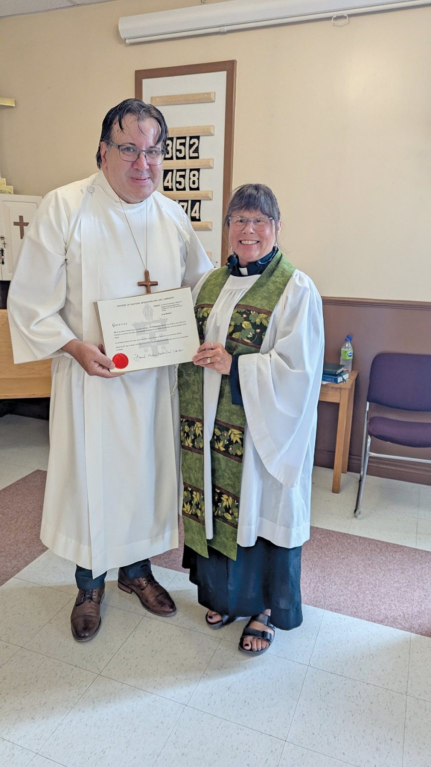 A man dressed in white alb receives a certificate from a woman, dressed in a surplice and green stole