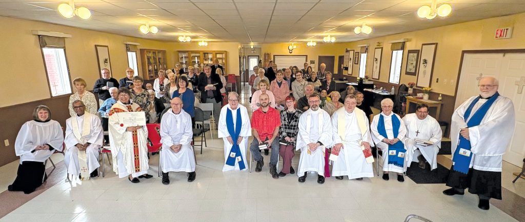 a large number of people gathered together in a church hall, some dressed in clerical vestments