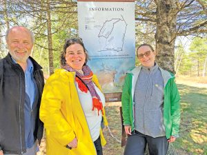 Three people in front of a sign in Debert NS Canada