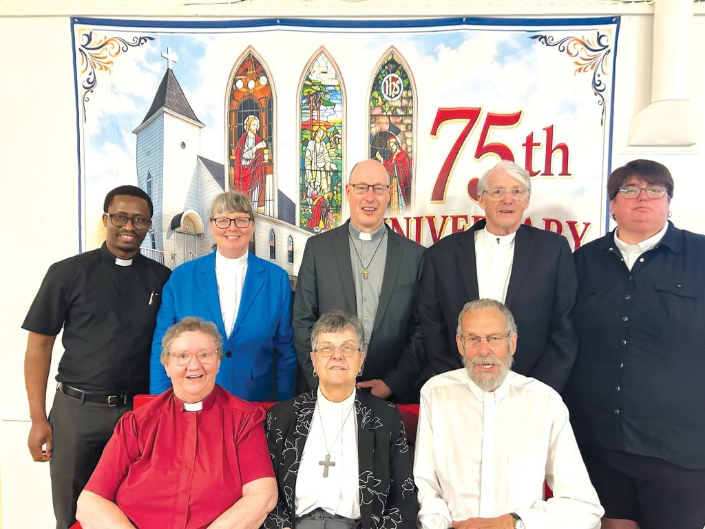 a group of 8 clergy, some seated in the front and some standing behind