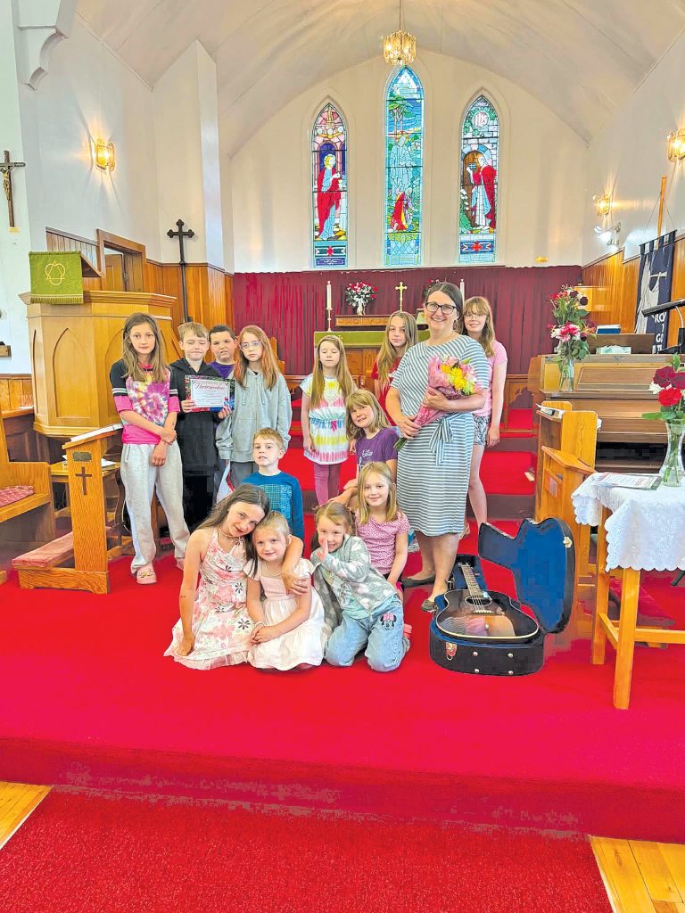 a group of young people and leaders at the front of a church that has bright red carpet