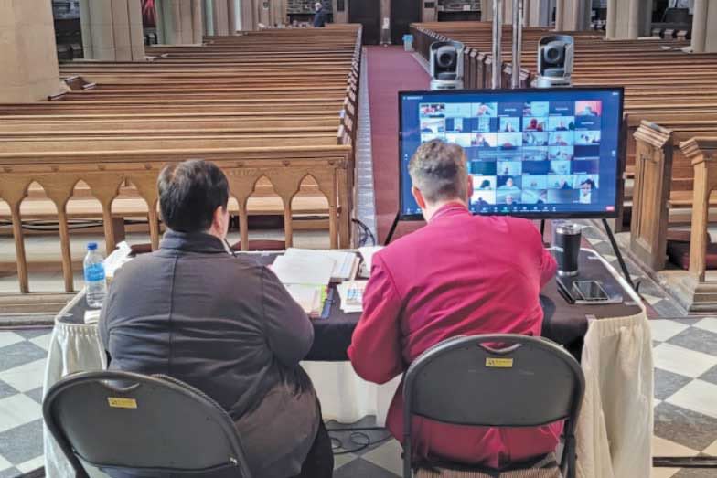 Archdeacon Taylor and Bishop Rose watch the synod delegates on Zoom